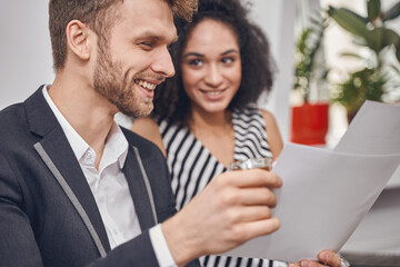 Two smiling young business partners sitting indoors