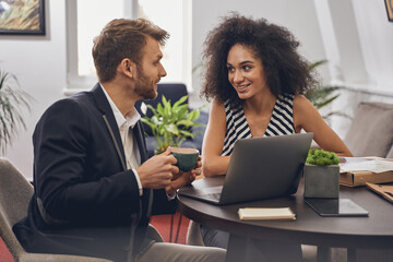 Man and his female coworker sitting at the table