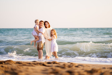 family stands on shore of sea with high waves. family vacation. trip.