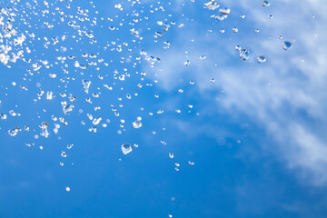 drops of water in the air against a blue sky. falling drops of water.