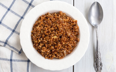 Buckwheat pilaf on wooden background.