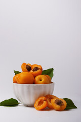 Bowl full of apricots on white background. Fresh juicy fruits