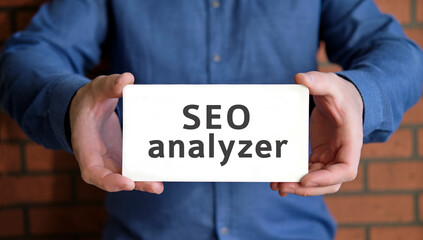 Seo analyzer - marketing concept check the site in the hands of a young man in a blue shirt
