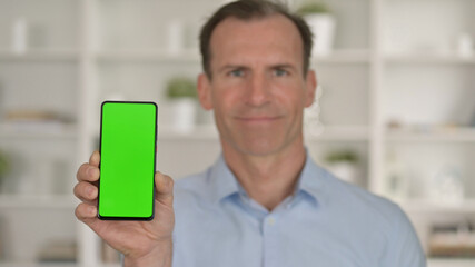 Portrait of Middle Age Businessman holding Smartphone with Chroma Key Screen
