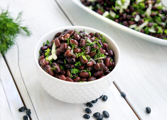 Black bean salad on wooden background.