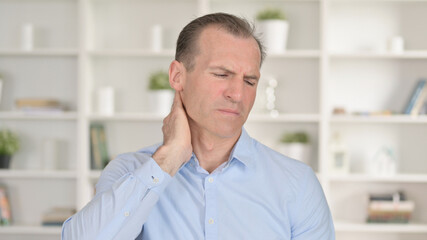 Fototapeta premium Portrait of Exhausted Middle Aged Businessman having Neck Pain