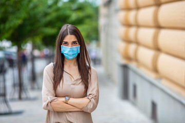 Portrait of an attractive young woman wearing a face mask to protect herself and others from...