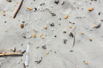 Pollution with microplastics, nurdles or small plastic granules, on the sand of the beach