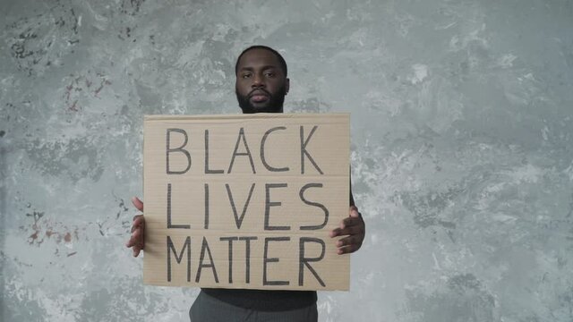 African american man, black activist showing banner with slogan "black lives matter"