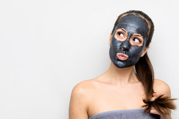 portrait of a beautiful young woman who does facial cosmetic procedures, skin with clay, advertising facial masks