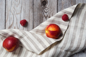 Peaches with raspberry on wooden background