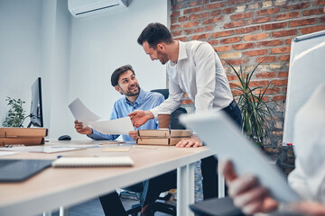 Young partners drawing up a contract in modern office