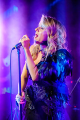 Girl singer sings on stage holding microphone