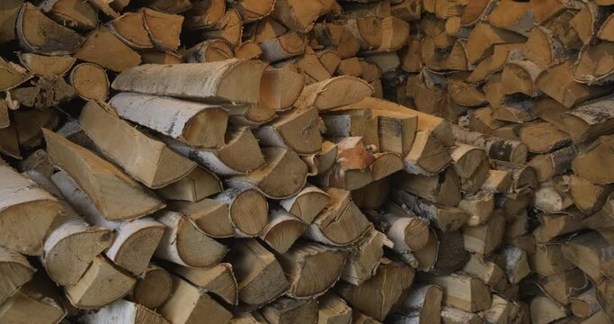 Small Village Warehouse with Firewood. Harvesting Wood Fuel for Winter. Heating house or bath. Life in Village. Stocks of Birch Chocks Lay Rows along Walls. Shed near the House. Village House