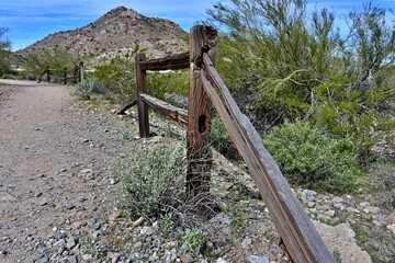 A partial split rail fence stands along a hiking trail in Arizona.