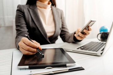 businesswoman hand working with laptop computer, tablet and smart phone in modern office with virtual icon diagram at modernoffice in morning light