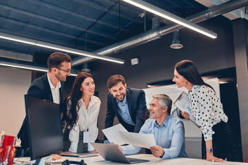 Young employees discussing new contract with mature chief in office