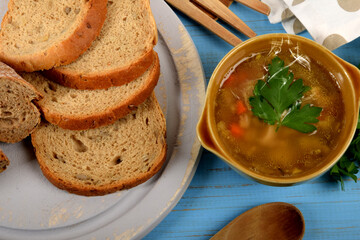 tripe in a small brown bowl with fresh green parsley next to dry bread