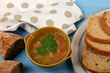 tripe in a small brown bowl with fresh green parsley next to dry bread