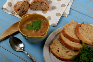 tripe in a small brown bowl with fresh green parsley next to dry bread