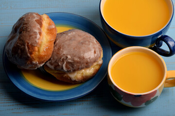 two sweet donuts and two cups of orange juice