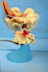 ice cream dessert with banana pieces and frozen raspberries on a teaspoon