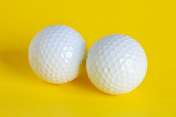 A white golf balls isolated on yellow background