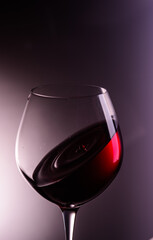 
a drop of wine flies into a wine glass
