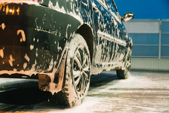Close up clean car concept at car wash. Washing car with soap. Car wash