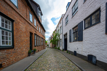 Narrow cobblestone alley with historic residential buildings in the old town of the hanseatic city Luebeck, Germany