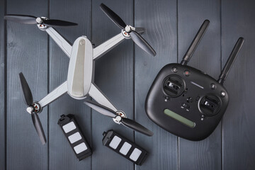 Four-engine drone with two spare batteries and dual frequency radio control on gray wooden background