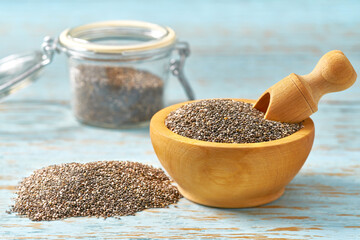chia seeds in a wooden bowl d on a blue  wooden table, with copy space.