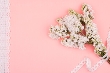 Obraz premium Spring bouquet of lilac on a pink background. The lace design.