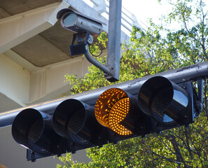 Traffic light in yellow with security cam