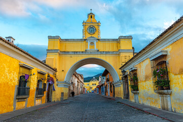 The Santa Catalina arch and the main street of Antigua city at sunrise, Guatemala.