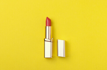 classy female lipstick as a make up item, close up shot on the yellow background in minimalism style - obrazy, fototapety, plakaty