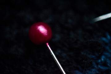 Macro of needles on a blue striped sweater 