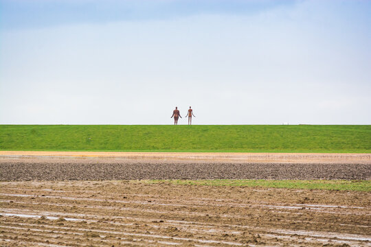 Holwerd, Netherlands - January 10, 2020.  Sculptures by the sea "Waiting for high water" by Jan Ketelaar in winter