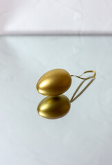 Golden egg on the mirrors. Christmas tree toy. Easter decoration.