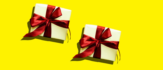  gift box with red ribbon on yellow background