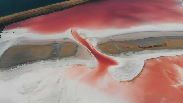 Amazing drone panoramic aerial landscape of beautiful salt plains. pink lake. Bright red salt deposits in artificial salt evaporators, salt mining. Top view