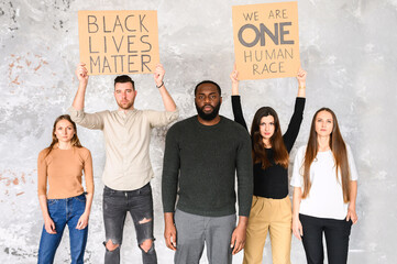 A protest against cruelty and racism. Multiracial group of young people with signs 