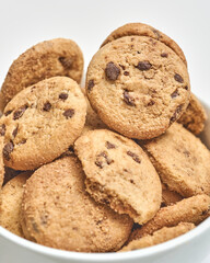 Group of chocolate chip cookies and crumbs on beige background