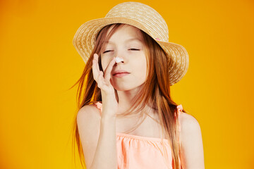 jolie jeune enfant fille caucasienne aux cheveux longs châtains mettant de la crème solaire sur...