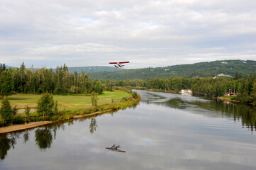 A sea plane or water plane takes off on the river into the Alaskan sky in the Fairbanks area of Alaska.