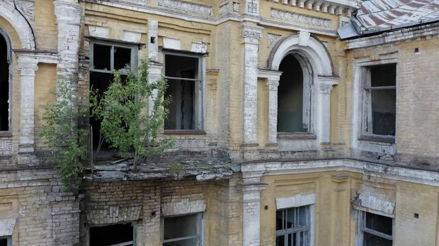 Abandoned old manor house (mansion house) with broken windows. Deserted 19th century building. Aerial side view