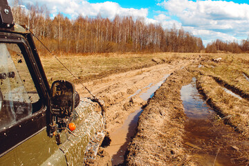 The SUV is stuck in the mud and pulled by a winch © Maxim