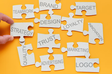 brand concept. puzzle pieces with inscriptions innovation, advertising, marketing, strategy, target, loyalty are scattered on the table