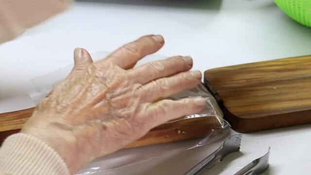 Smashing pieces of plantain to make traditional patacones or tostones