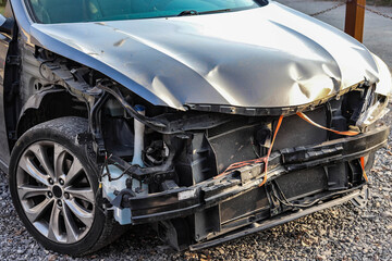 Damaged front of the car disassembled with a view of the engine without bumper headlights and fender